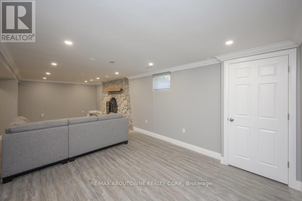 A spacious living room with a grey sofa and a stone fireplace.