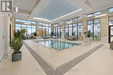 A large indoor swimming pool in a spacious room with a high ceiling and large windows.