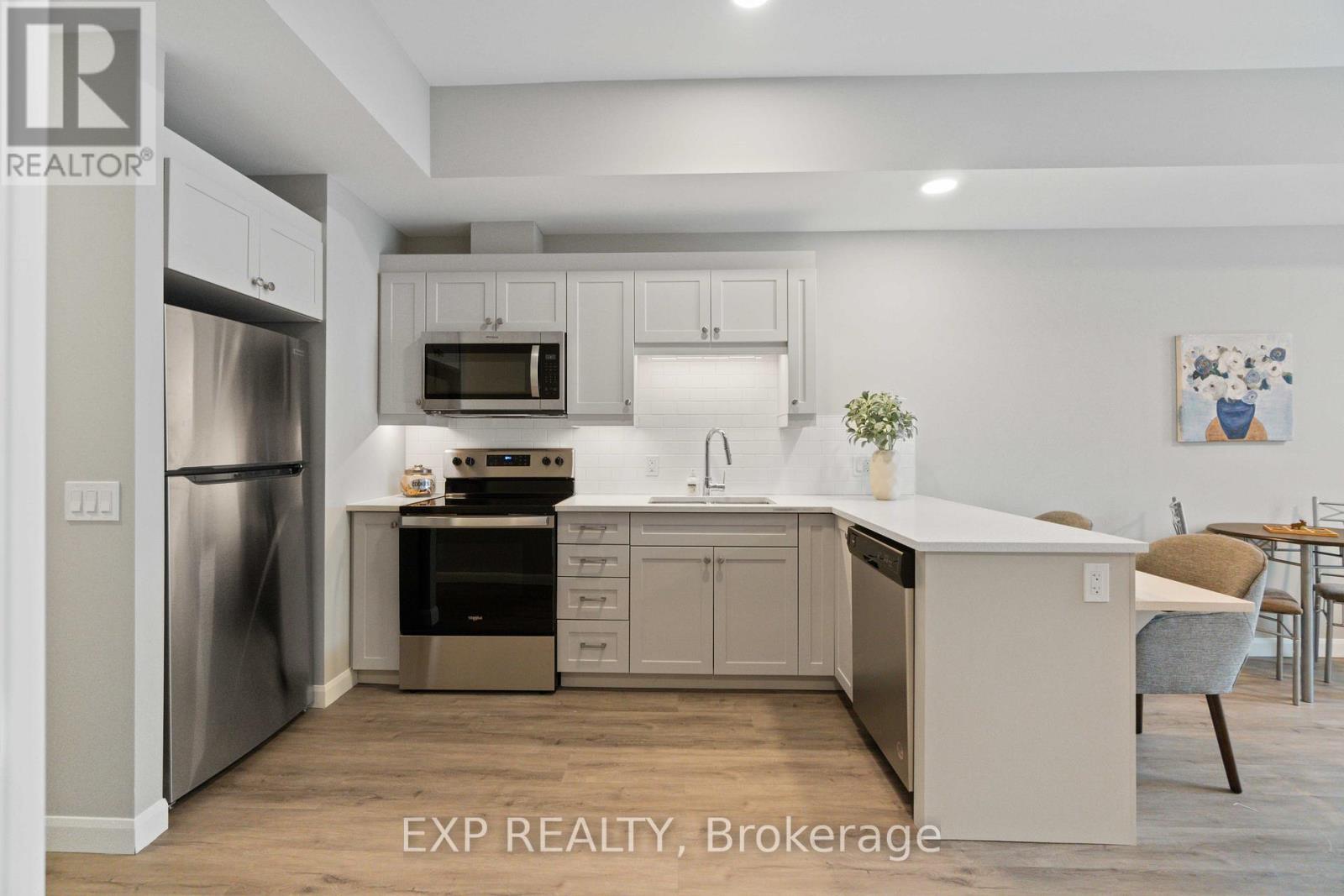 A kitchen with white cabinets and a stainless steel refrigerator.