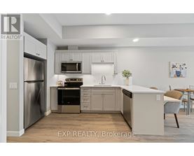 A kitchen with white cabinets and a stainless steel refrigerator.
