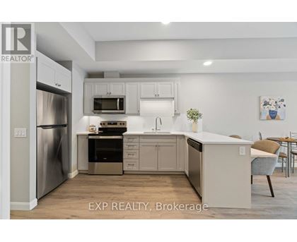 A kitchen with white cabinets and a stainless steel refrigerator.