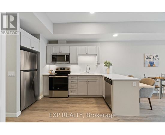 A kitchen with white cabinets and a stainless steel refrigerator.
