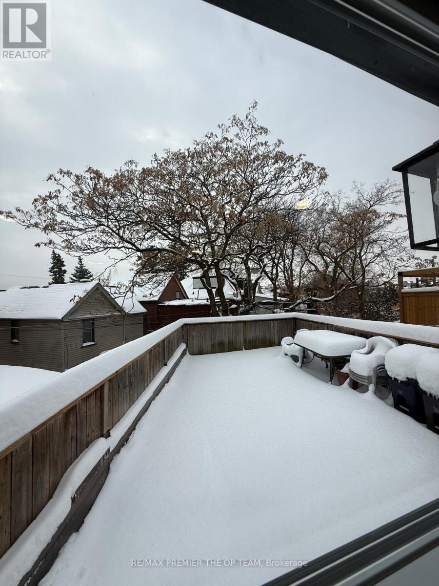 A snow-covered landscape with a house and trees in the background.