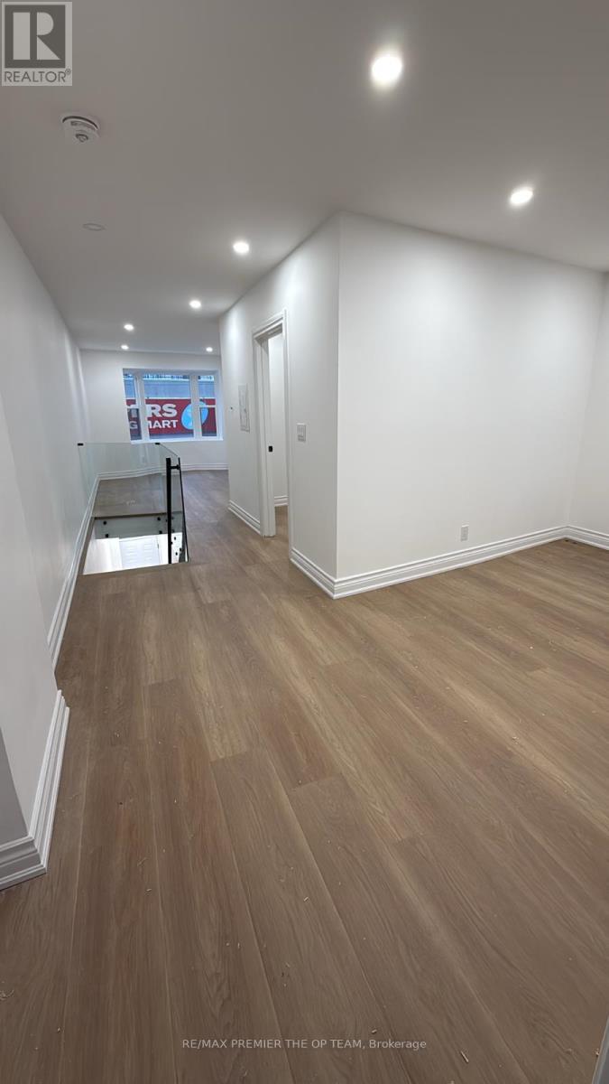 A long hallway with wood floors and white walls.