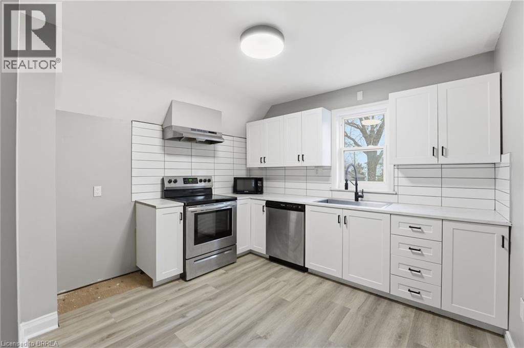 A kitchen with white cabinets and a stove top oven.
