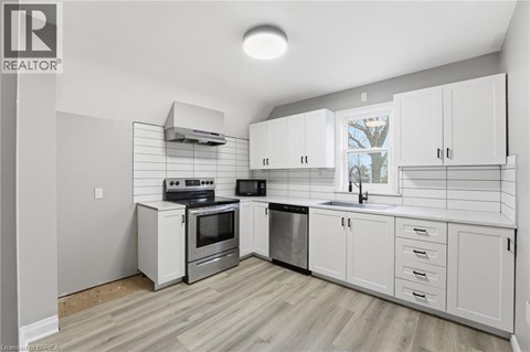 A kitchen with white cabinets and a stove top oven.