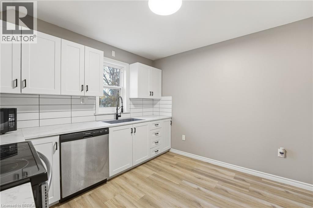 A kitchen with white cabinets and a black stove top oven.
