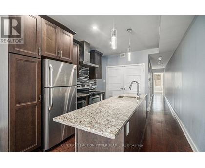 A kitchen with wooden cabinets and a marble countertop.