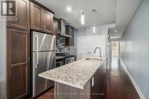 A kitchen with wooden cabinets and a marble countertop.