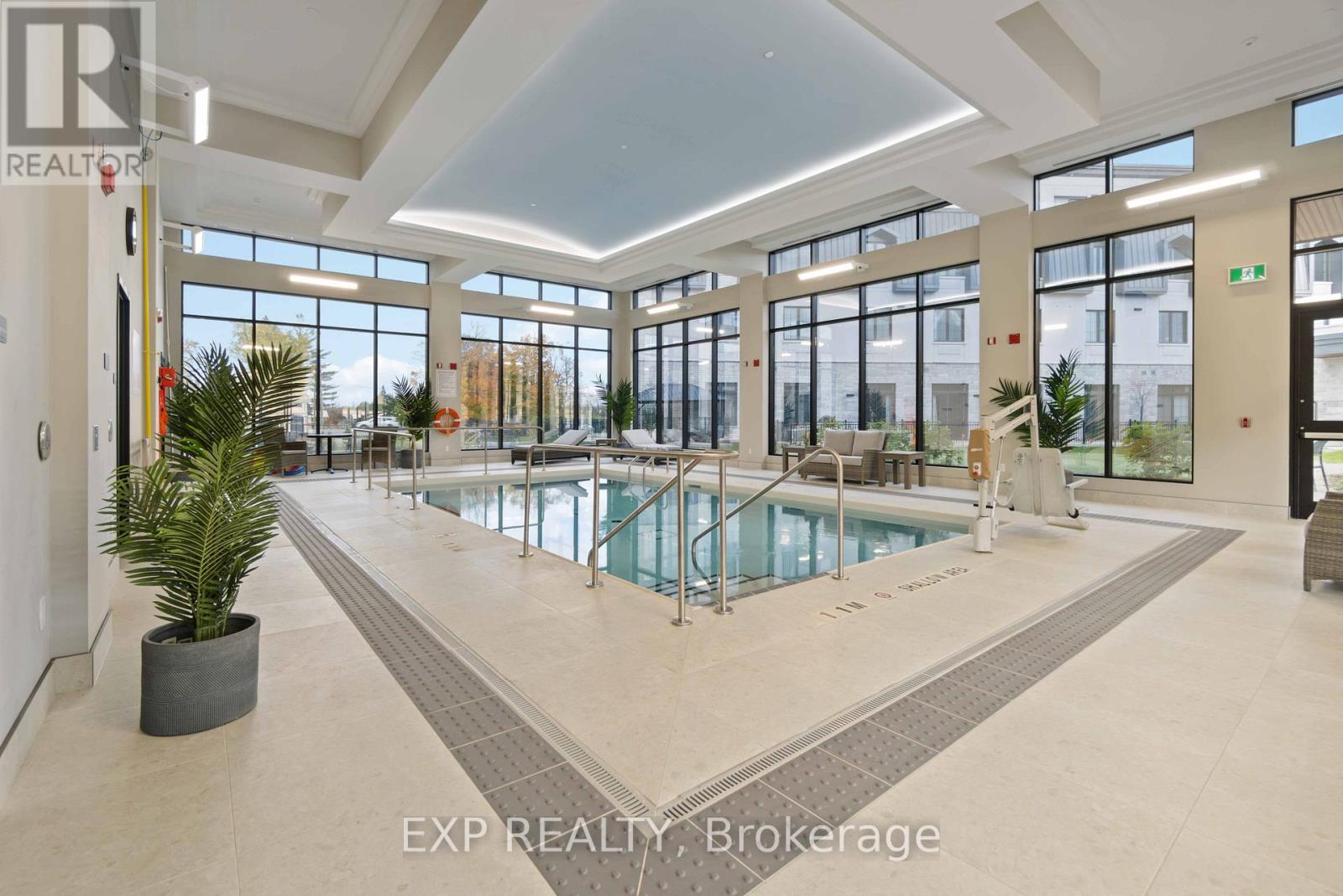 A large indoor swimming pool in a spacious room with a high ceiling and large windows.