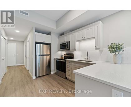 A kitchen with white cabinets and a stainless steel refrigerator.