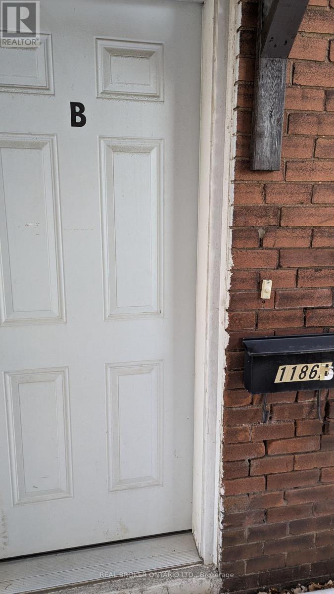 A white door with a mailbox on the side of a brick building.