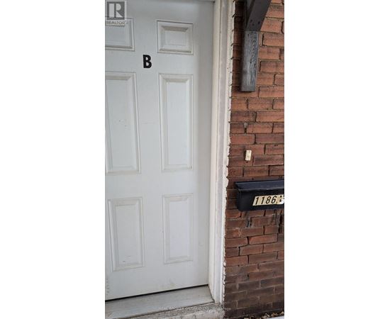 A white door with a mailbox on the side of a brick building.
