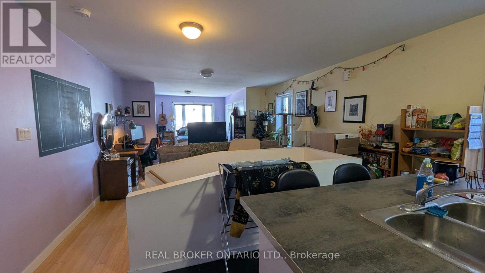 A kitchen with a sink and a dining table with chairs.
