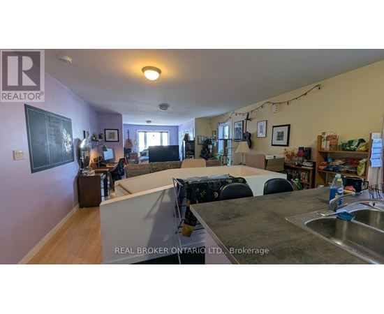A kitchen with a sink and a dining table with chairs.