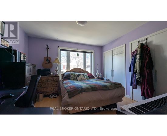 A bedroom with a bed, a guitar, a piano, and a window.