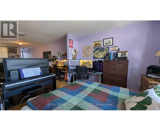 A bedroom with a bed, a piano, and a bookshelf.