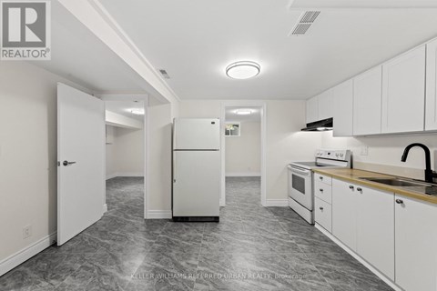 A kitchen with white cabinets and a marble floor.