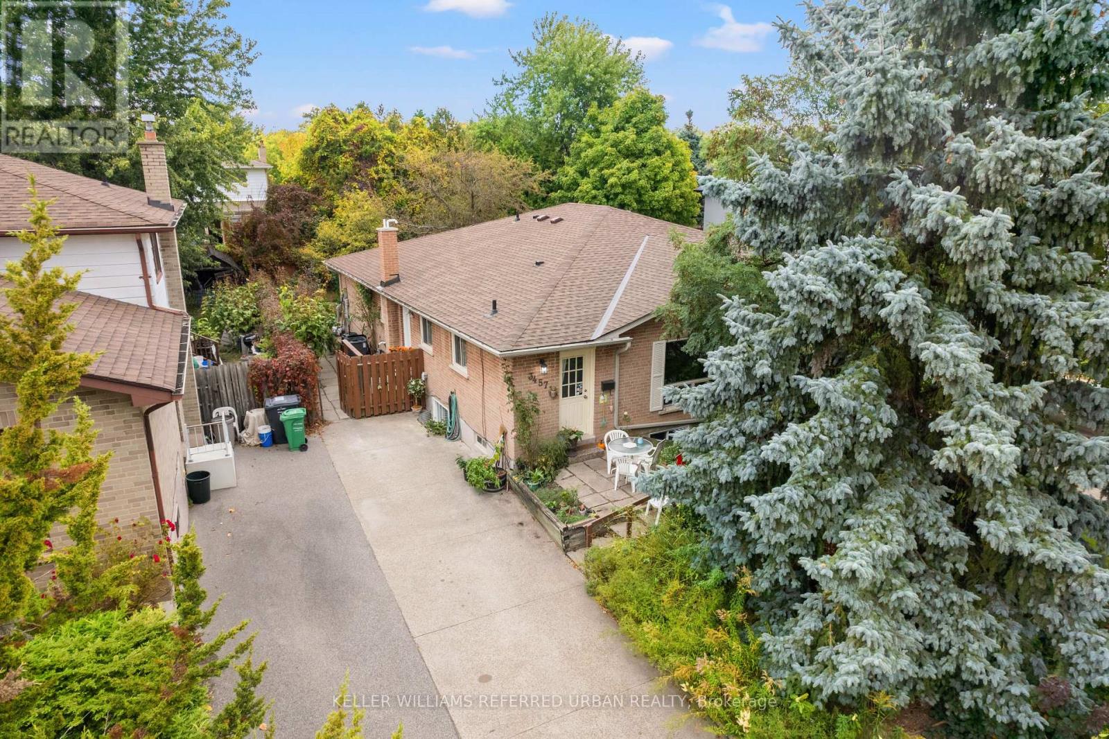 A house with a driveway and trees in the background.