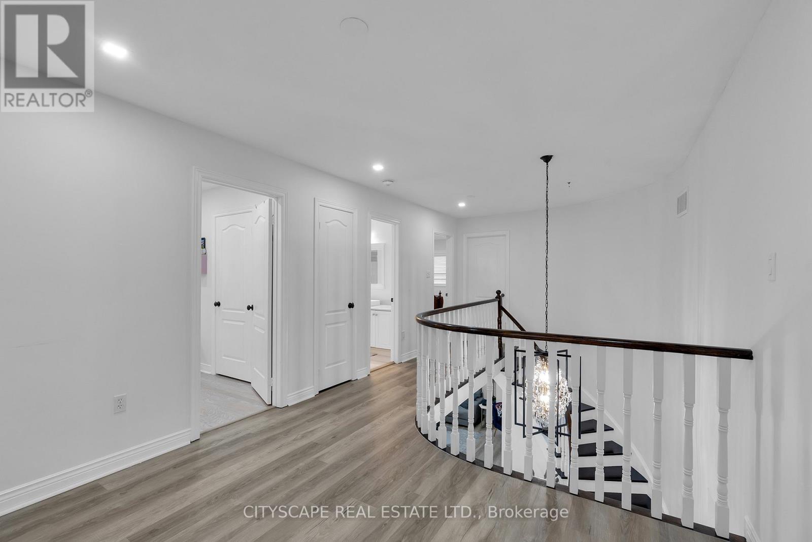 A spacious room with a staircase and a chandelier.