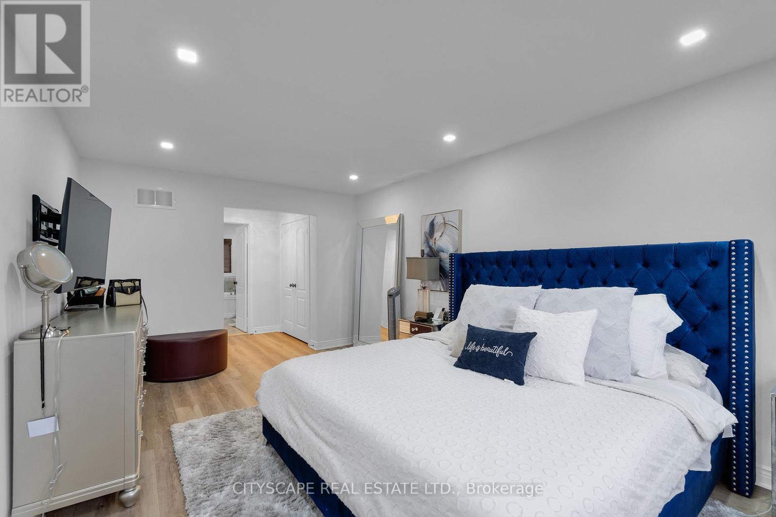 A bedroom with a white bed and blue headboard.