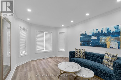 A living room with a blue couch and a painting on the wall.