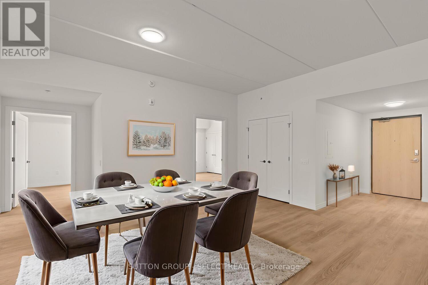 A dining room with a table set for four and chairs around it.