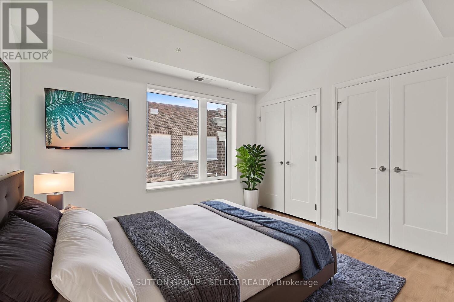 A bedroom with two beds and a large window.