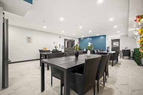A dining room with a long table and chairs.