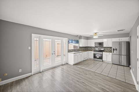 A kitchen with white cabinets and a tile backsplash.