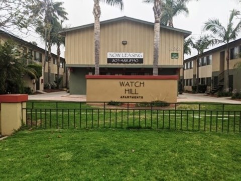 Watch Hill Apartments is a beige building with a sign in front.