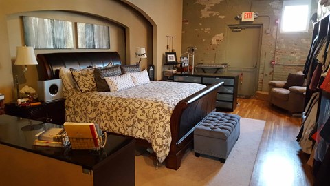 A bedroom with a large bed and a black headboard.