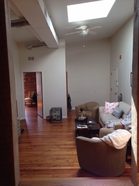 A living room with a brown chair and a white couch.
