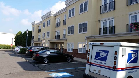 A USPS truck is parked in front of a building.