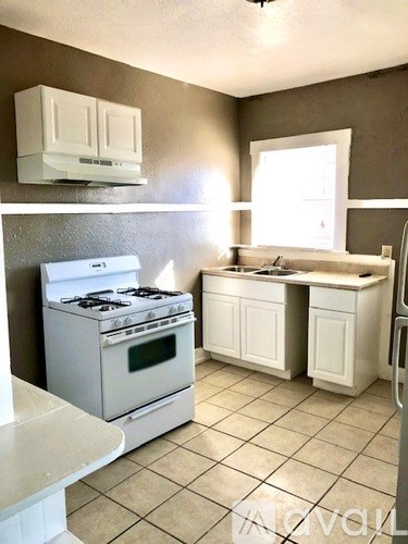 A white stove and oven in a kitchen with white cabinets.