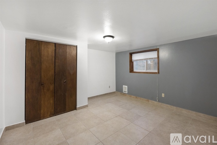 A room with a wooden door and a window with a white frame.