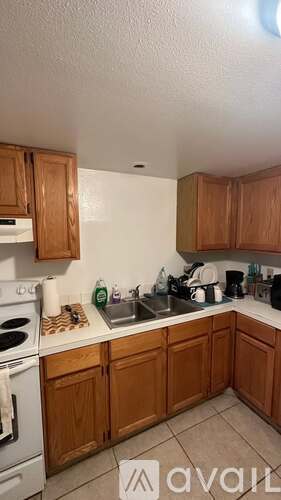A kitchen with wooden cabinets and a white stove top oven.