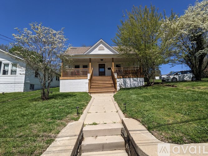 A house with a front yard and a tree with white flowers.