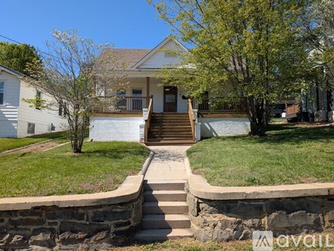 A house with a front yard and a tree with white flowers.