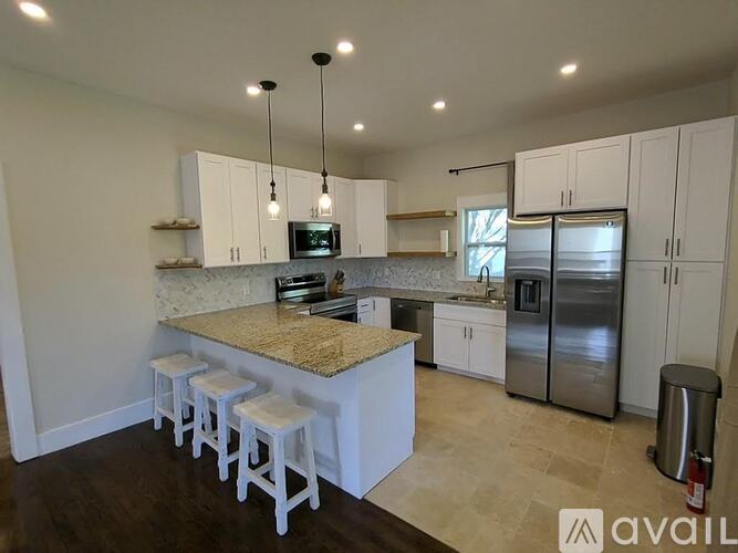 A kitchen with a granite countertop and white cabinets.