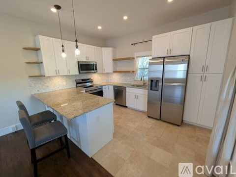 A kitchen with a granite countertop and white cabinets.