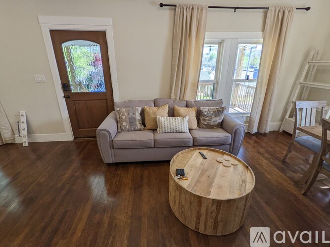 A living room with a grey couch and a wooden coffee table.