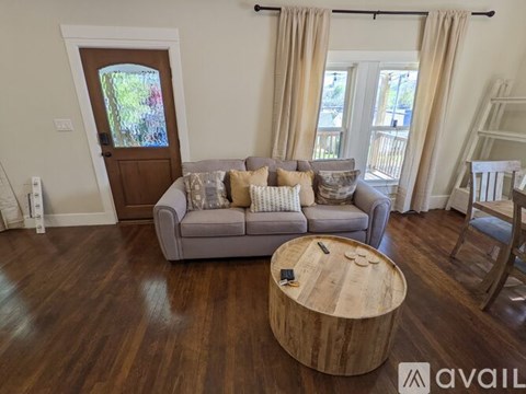 A living room with a grey couch and a wooden coffee table.