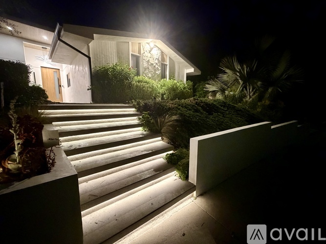 A house with a lit up staircase leading to the front door.