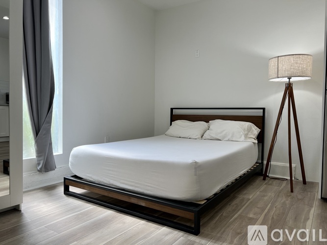 A bedroom with a large bed and a lamp.