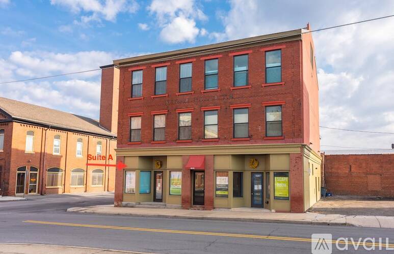 A red brick building with a green awning and a sign that says suite A.