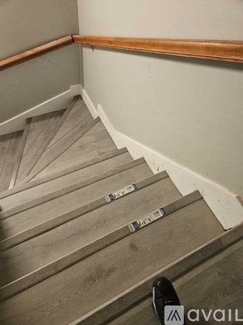 A set of wooden stairs with metal handrails.