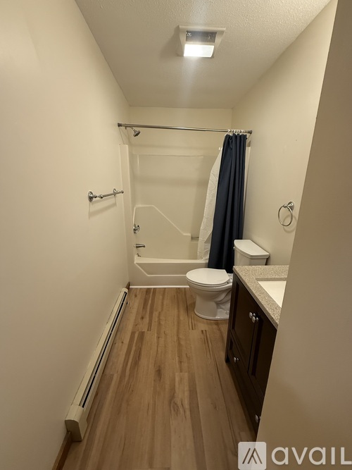 A small bathroom with a toilet, sink, and shower.