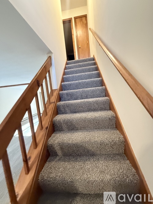 A staircase with a carpeted runner and wooden balusters.