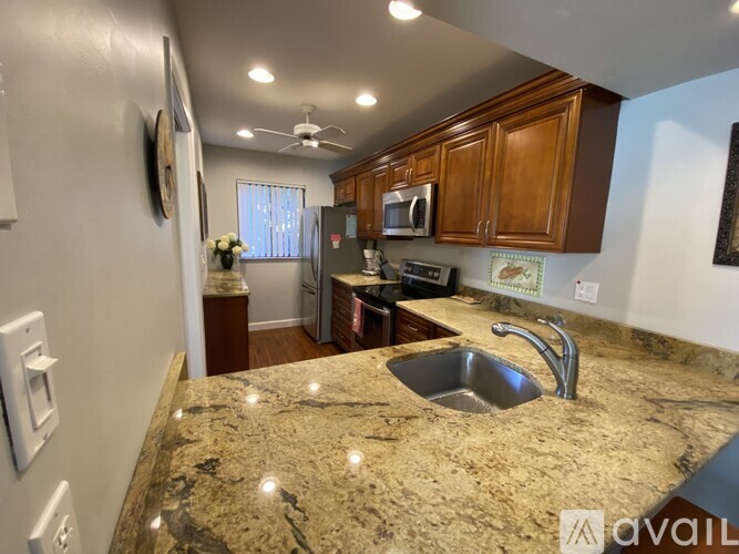 A kitchen with granite countertops and wooden cabinets.